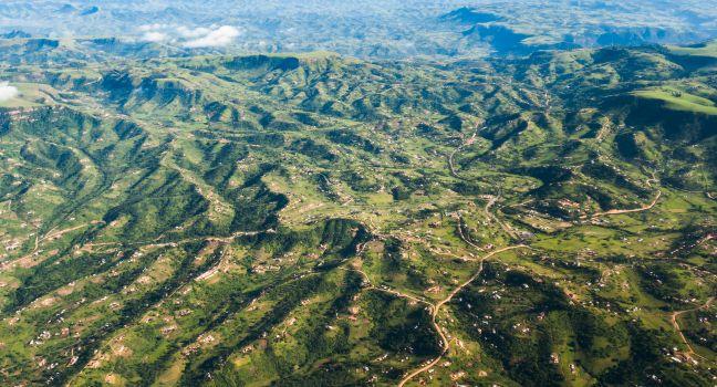 Air Flying Landscape Rural Habitat Air flying birds eye view of rural habitat homes in thousand hills terrain landscape .