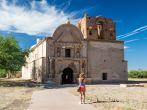 A woman visitor take a picture of the preserved Spanish mission at Tumacacori, Arizona.