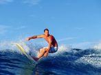 Photo of surfer Chris Gagnon riding a longboard while surfing at Waikiki Beach in Hawaii.