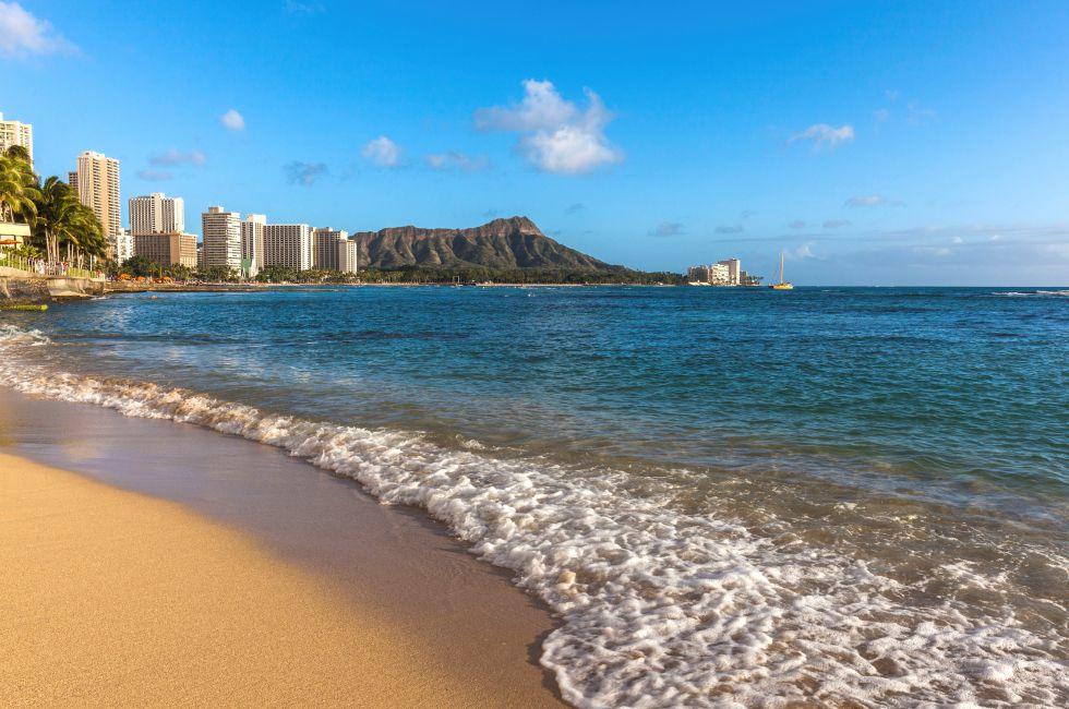 On the beach of Waikiki with Diamond Head Volcano in the background.