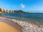 On the beach of Waikiki with Diamond Head Volcano in the background.