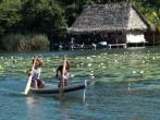 RIO DULCE, GUATEMALA -  DECEMBER 6: Children are rowing in a small boat near white lilies,at the arrival of tourists to sell them home made presents on December 6, 2013, in Rio Dulce, Guatemala.