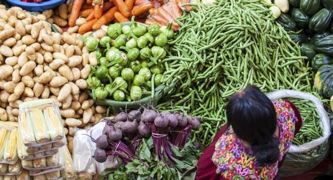 CHICHICASTENANGO, GUATEMALA- MAY 9: An unidentified woman sells vegetables at traditional weekly market in Chichicastenango (Chichi), Guatemala on 9 May 2013.