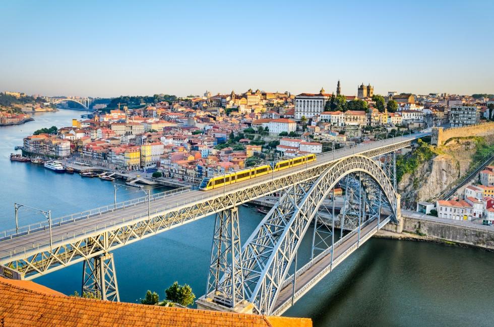 View of the historic city of Porto, Portugal with the Dom Luiz bridge. A metro train can be seen on the bridge; Shutterstock ID 148234274; Project/Title: Fodors Portugal Gold Guide; Destination: Portugal; Downloader: Jessica Parkhill