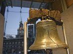 Close-up shot of the Liberty Bell with Independence Hall in the background at dusk. Located in downtown Philadelphia
