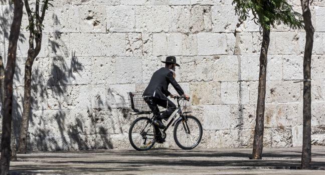 JERUSALEM, ISRAEL - MAY 26: Hassid rides a bicycle past the Jaffa Gate. The Western Wall is the most sacred sites in Judaism, it attracts thousands of devotees every day, on May 26, 2013 in Jerusalem; Shutterstock ID 142560175; Project/Title: Israel ebook