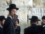 Clutching a siddur prayer book and sporting payos sidelocks, a Jew gathers at the Wiiling Wall where solemn prayers are scribbed and stuffed into the seams of the stone. Jerusalem, Isreal